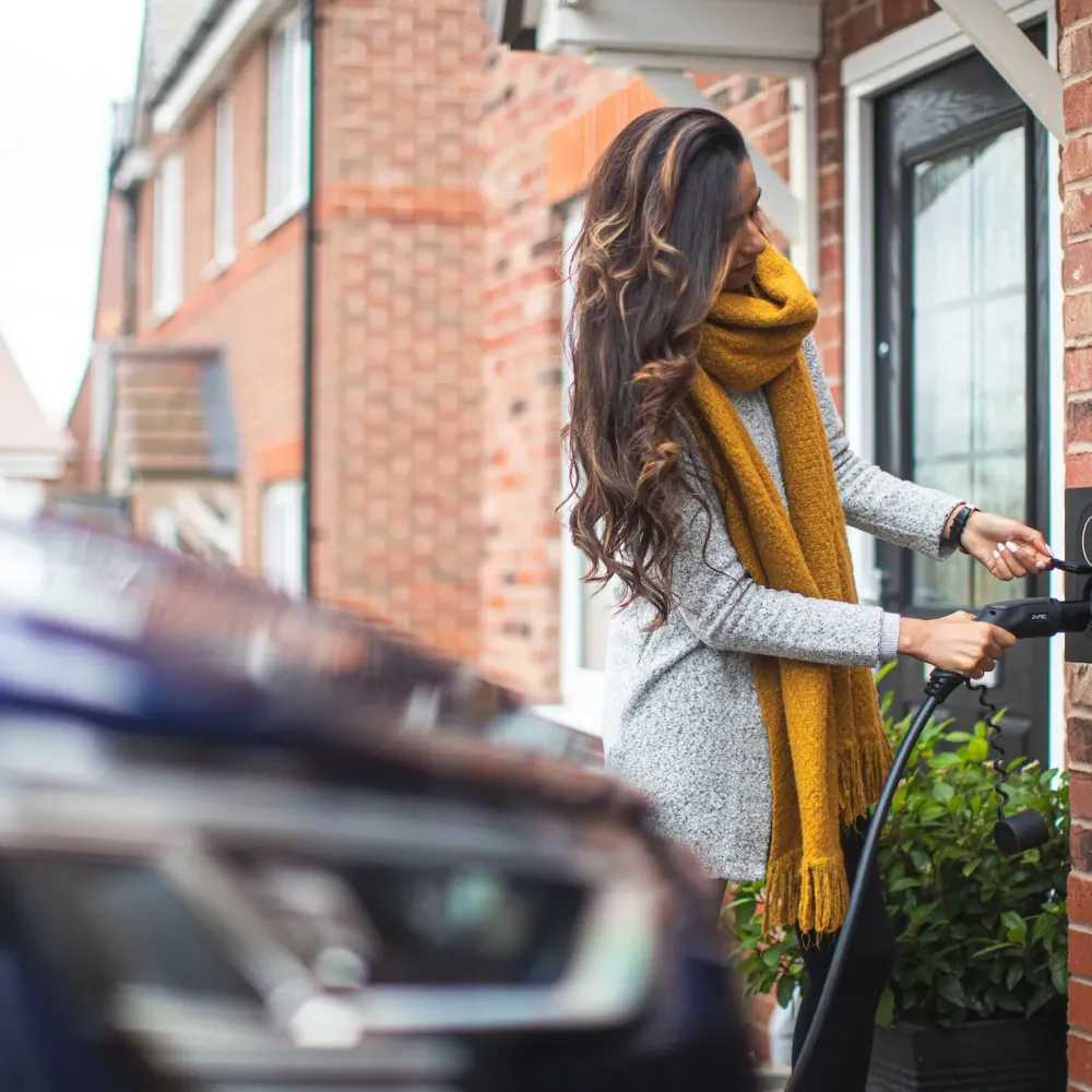 A driver using a home wall-mounted EV charger